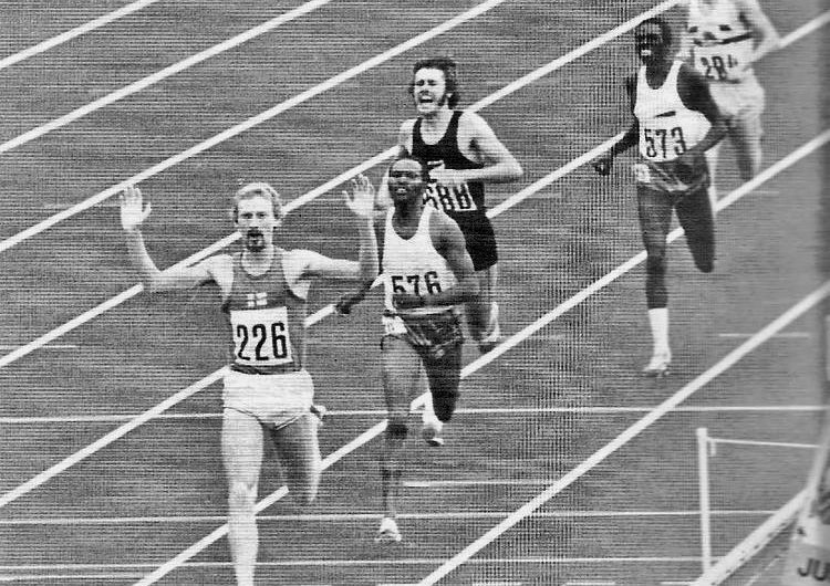 Finland’s Pekka Vasala wins the 1972 Olympic 1500m final,arms raised in triumph winning a gold medal. A short stride behind Vasala, Kipchoge Keino, looks angry and disappointed in second place, Rod Dixon is shouting excitedly